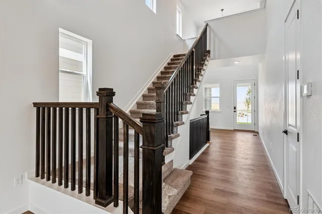 a view of a hallway with wooden floor and staircase