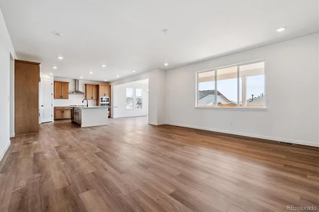 a view of open kitchen with wooden floor and a window