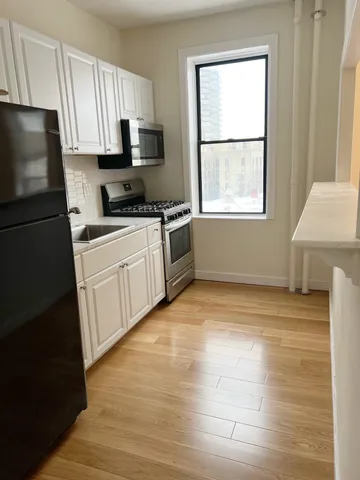 a kitchen with stainless steel appliances granite countertop a refrigerator sink and microwave