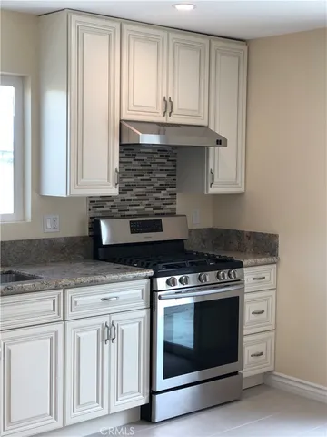a kitchen with granite countertop white cabinets and appliances