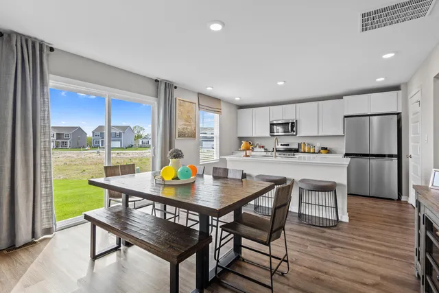 a kitchen with a table chairs refrigerator and cabinets