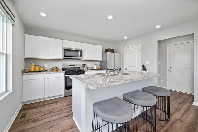 a kitchen with a dining table chairs and refrigerator