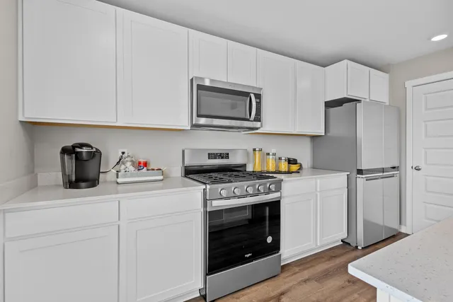 a kitchen with stainless steel appliances granite countertop a stove a microwave and a refrigerator