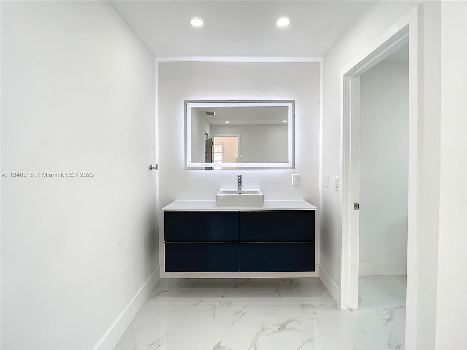 14031 Langley Place Davie, FL 33325 - Photo 12 of 27 a room with a sink and a mirror