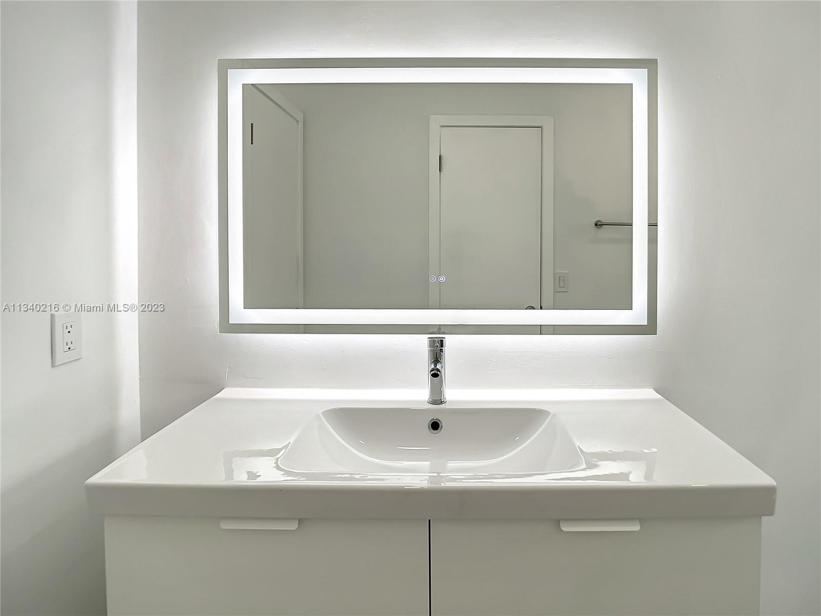 14031 Langley Place Davie, FL 33325 - Photo 19 of 27 a bathroom with a sink and a mirror