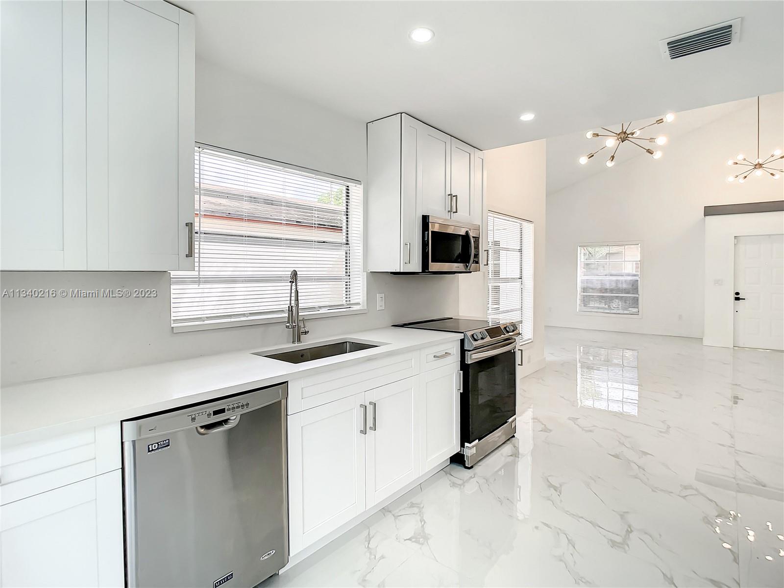 14031 Langley Place Davie, FL 33325 - Photo 3 of 27 a kitchen with stainless steel appliances granite countertop a sink stove and refrigerator