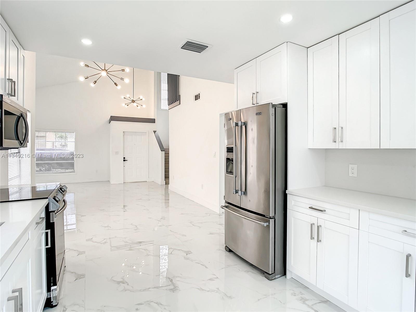 14031 Langley Place Davie, FL 33325 - Photo 4 of 27 a kitchen with stainless steel appliances a refrigerator sink and cabinets