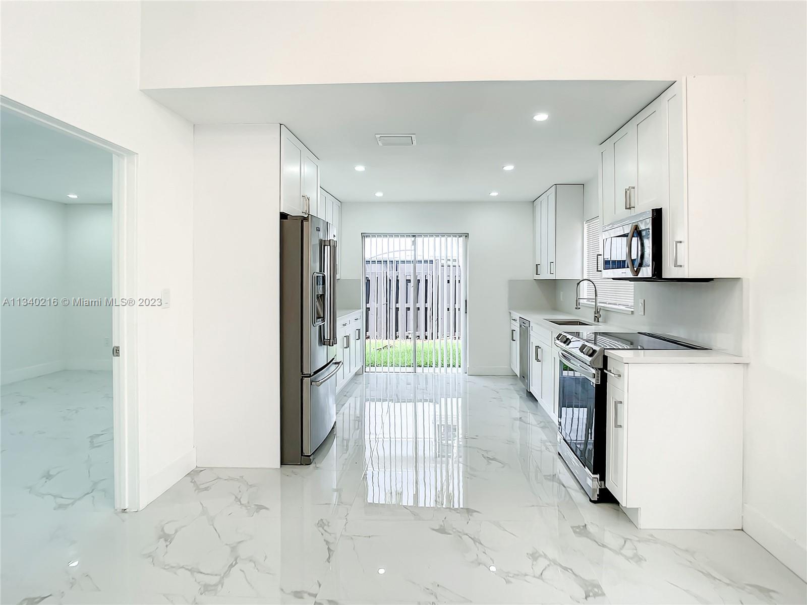 14031 Langley Place Davie, FL 33325 - Photo 5 of 27 a large kitchen with cabinets