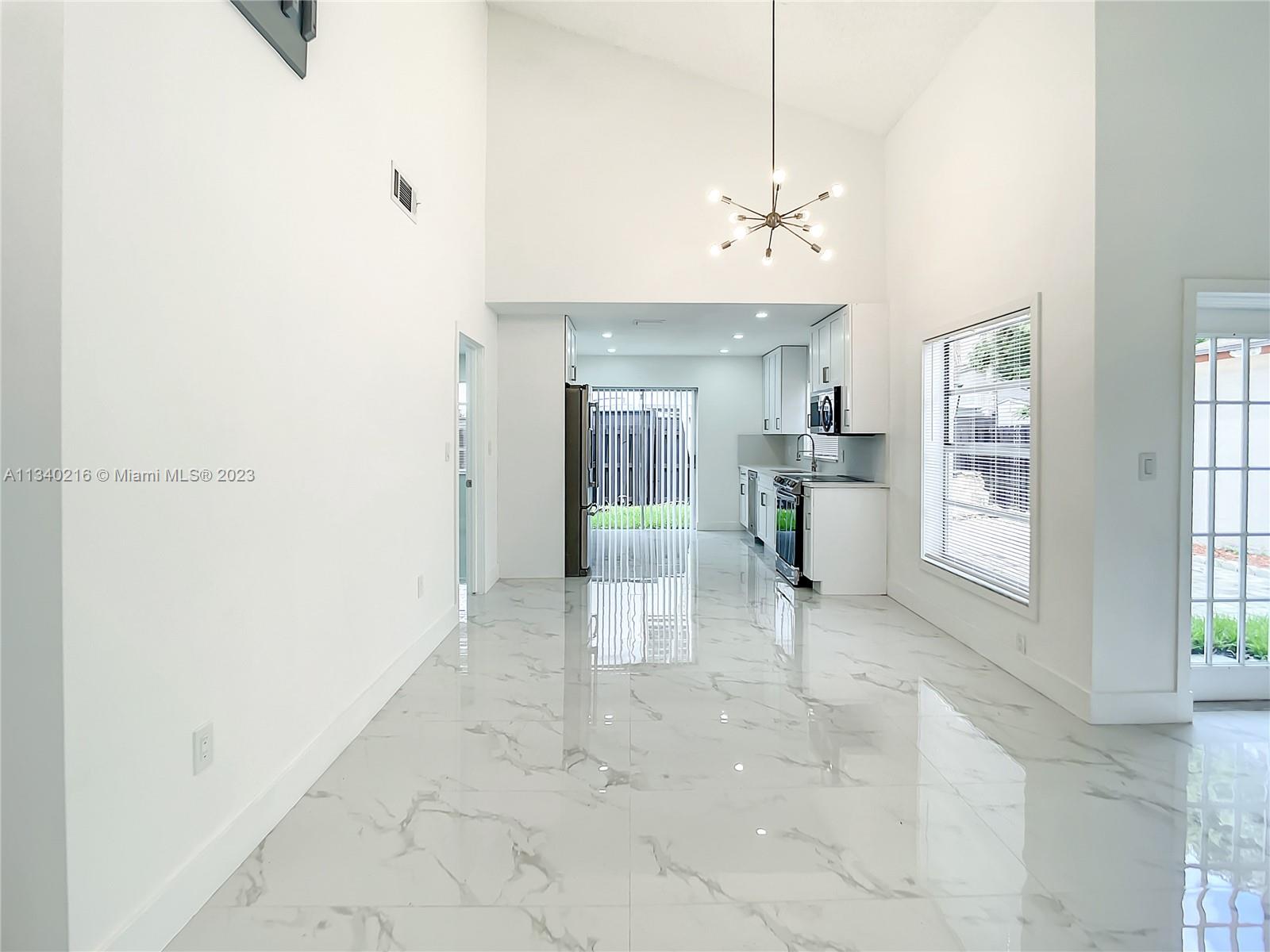 14031 Langley Place Davie, FL 33325 - Photo 6 of 27 a view of a hallway with a chandelier