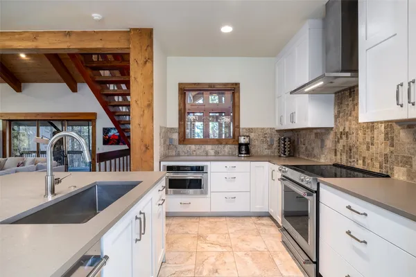 a kitchen with stainless steel appliances a sink stove and cabinets