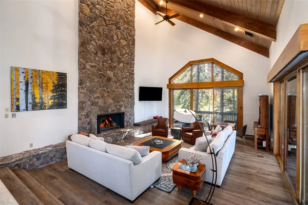 a living room with furniture a fireplace and a large window