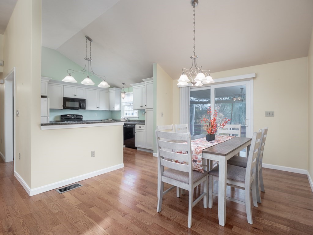 83 Cherry Street Taunton, MA 02780 - Photo 17 of 42 a view of a dining room and livingroom with furniture wooden floor a chandelier