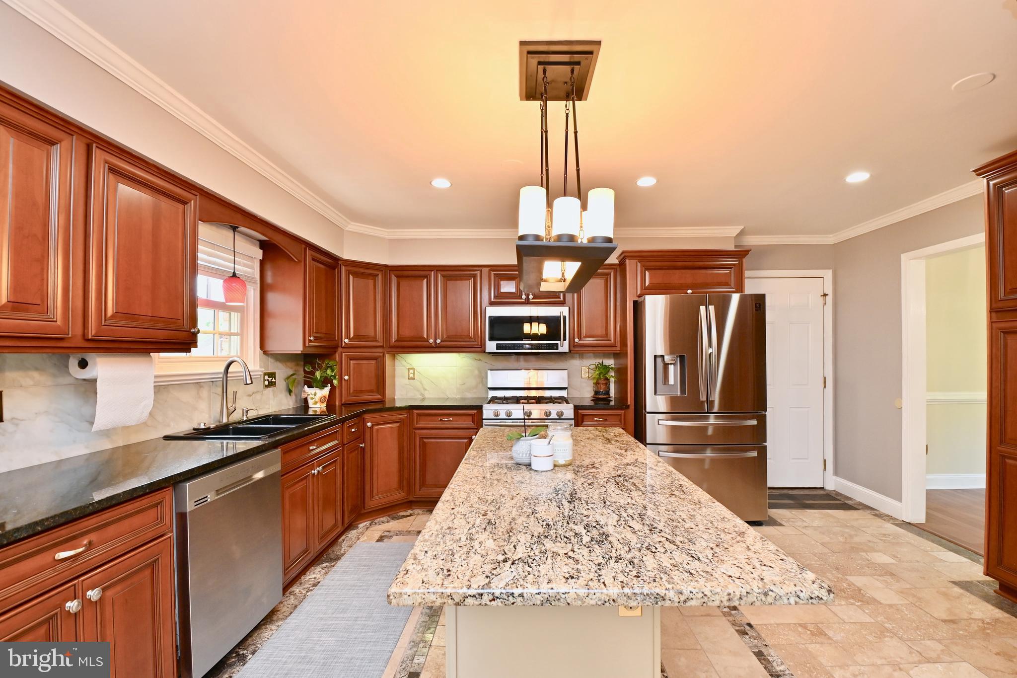 a kitchen with stainless steel appliances kitchen island granite countertop a sink and a wooden cabinets