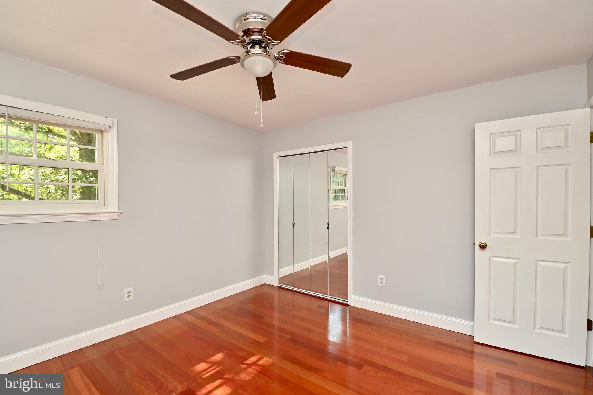 4319 Old Mill Road Alexandria, VA 22309 - Photo 54 of 86 an empty room with wooden floor chandelier fan and windows