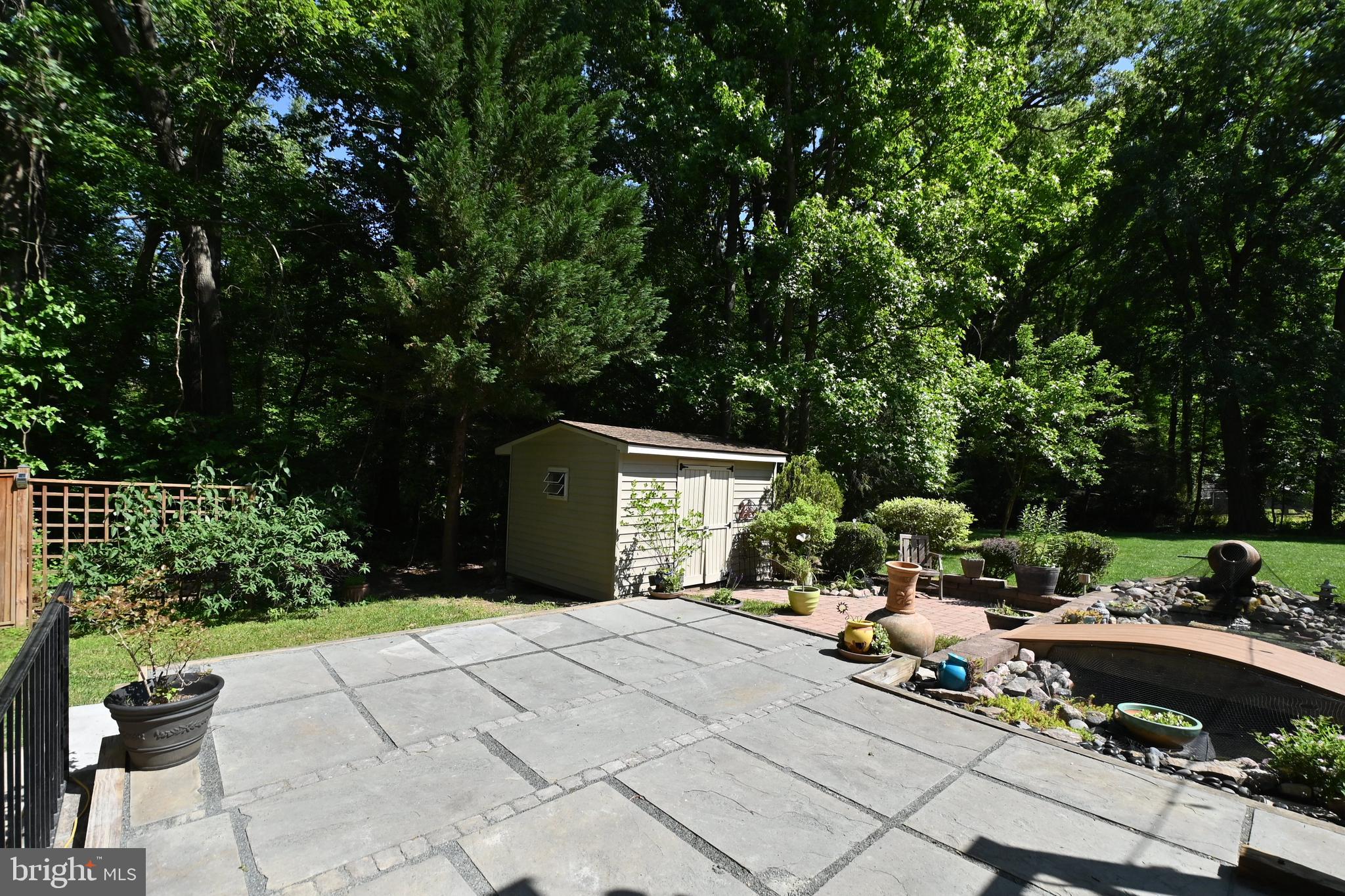 4319 Old Mill Road Alexandria, VA 22309 - Photo 73 of 86 a backyard of a house with table and chairs potted plants with large tree