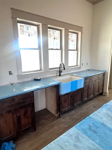 a kitchen with a sink a window and wooden floor