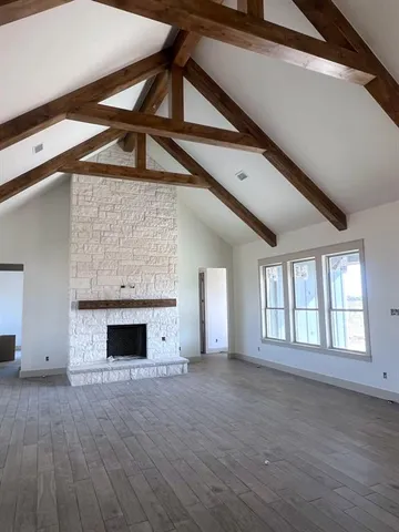 a view of empty room with wooden floor and fireplace