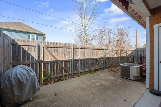 a view of backyard with tub and wooden fence