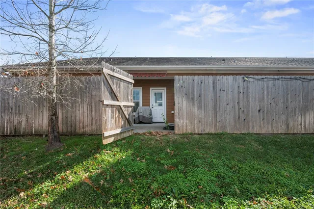 a view of a backyard with potted plants and wooden fence