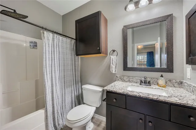 a bathroom with a granite countertop sink toilet and shower