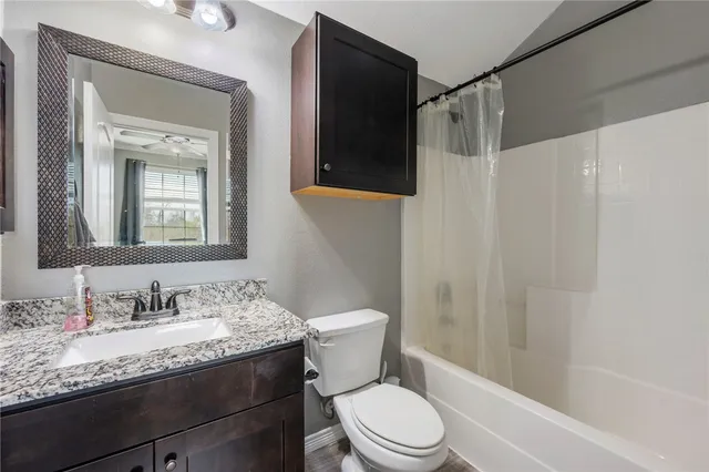 a bathroom with a granite countertop sink toilet and shower