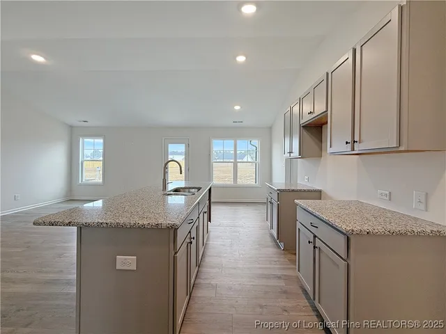 a kitchen with stainless steel appliances granite countertop a sink a stove and a refrigerator