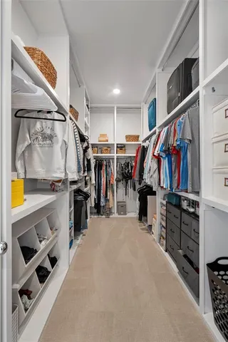 a view of walk in closet with clothes and shoes