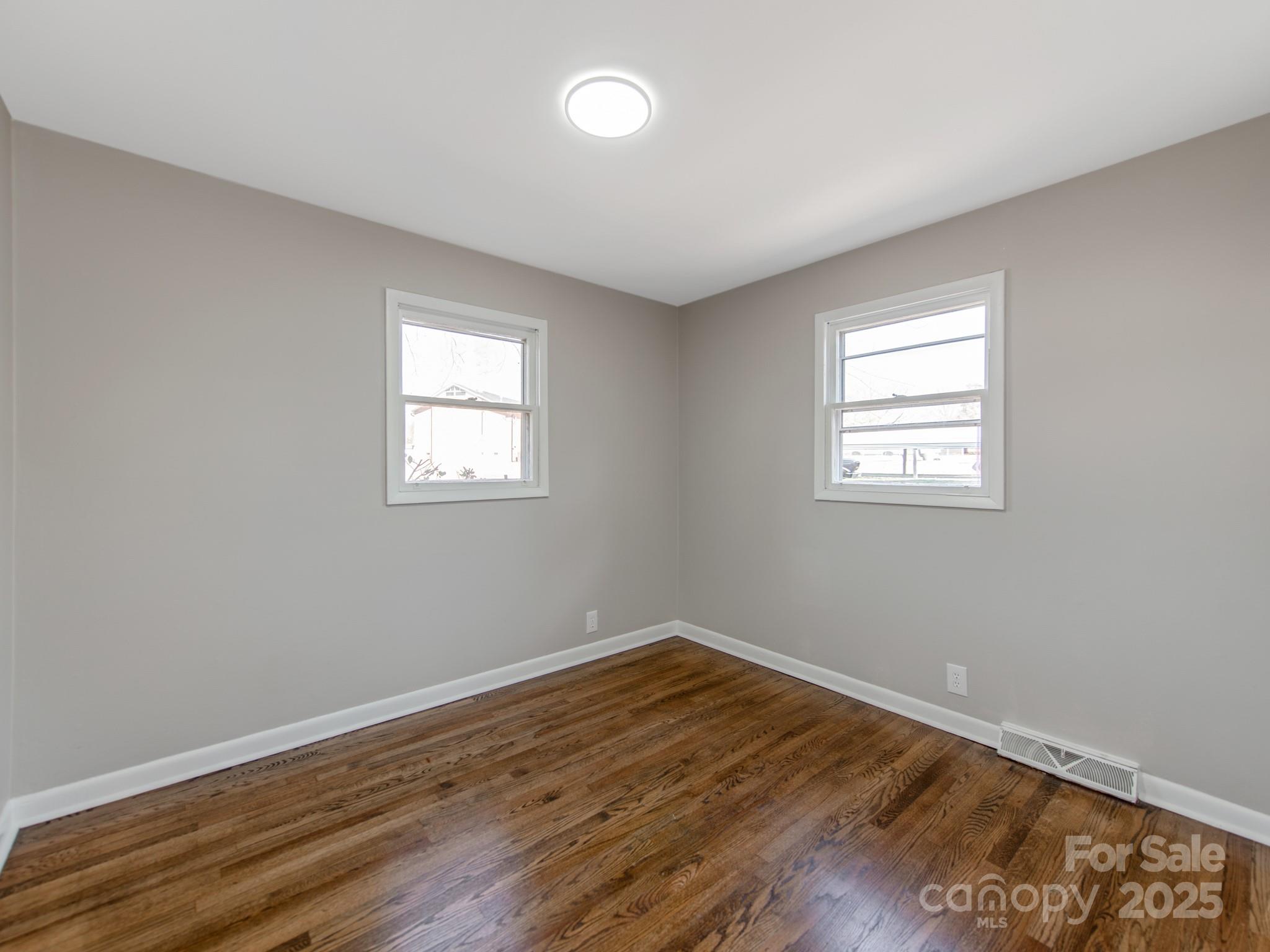 502 McConnell Street Clover, SC 29710 - Photo 16 of 25 an empty room with wooden floor and windows