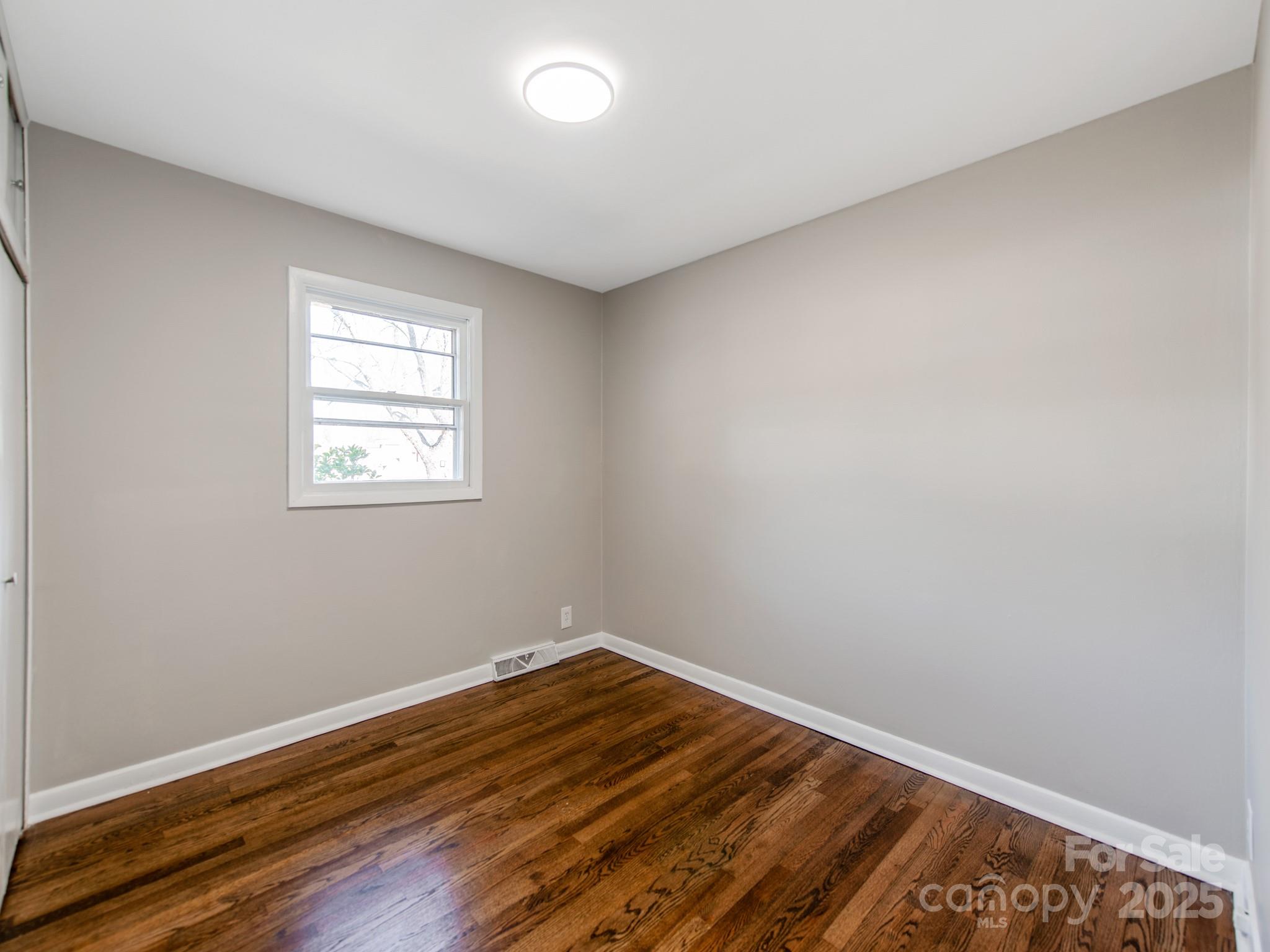 502 McConnell Street Clover, SC 29710 - Photo 18 of 25 an empty room with wooden floor and windows