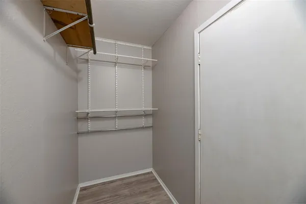a view of walk in closet with empty racks