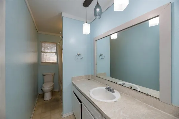 a bathroom with a sink a toilet and shower a mirror