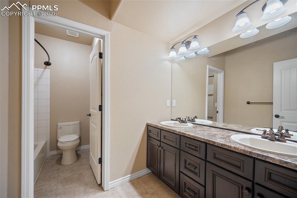 1117 Spectrum Loop Colorado Springs, CO 80921 - Photo 19 of 31 a bathroom with a double vanity sink toilet and a mirror