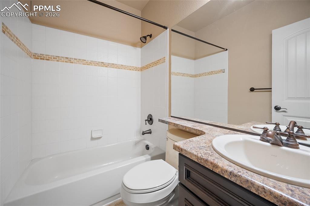 1117 Spectrum Loop Colorado Springs, CO 80921 - Photo 24 of 31 a bathroom with a granite countertop sink a toilet and shower