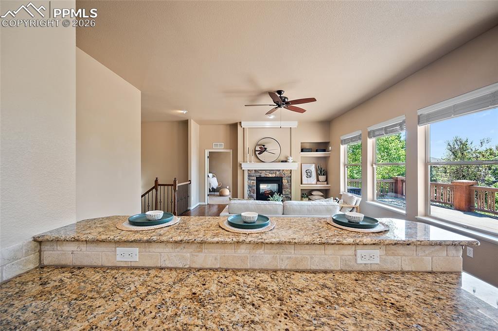 1117 Spectrum Loop Colorado Springs, CO 80921 - Photo 8 of 31 a living room with granite countertop furniture a fireplace and a large window