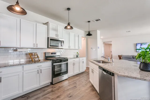 a kitchen with a sink stove and microwave