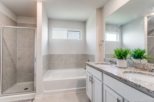 a bathroom with a granite countertop sink a mirror a bathtub and shower