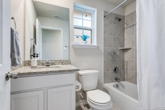 a bathroom with a granite countertop sink toilet and shower
