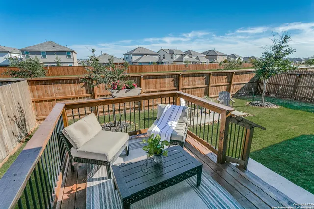 a view of a balcony with wooden floor and outdoor seating