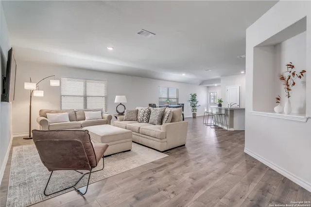 a living room with furniture and a wooden floor