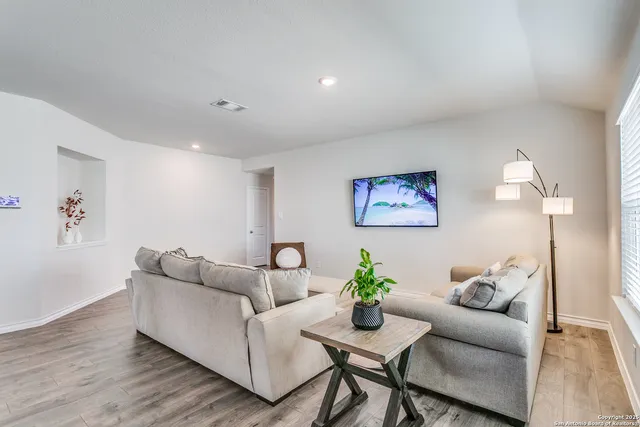 a living room with furniture and wooden floor