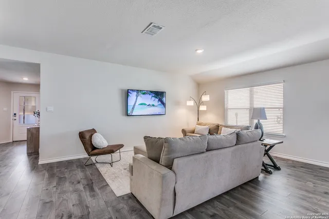 a living room with furniture and a wooden floor
