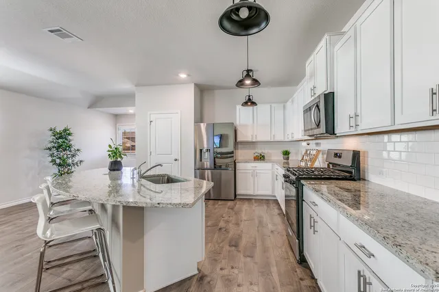 a kitchen with stainless steel appliances granite countertop a sink dishwasher stove top oven and refrigerator