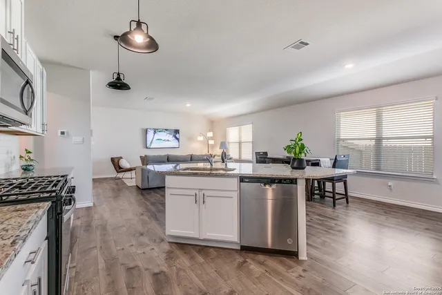 a kitchen with counter space appliances and wooden floor