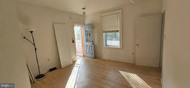 an empty room with wooden floor & closet