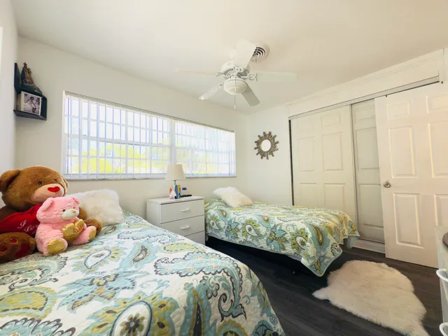 a bedroom with a large bed and wooden floor