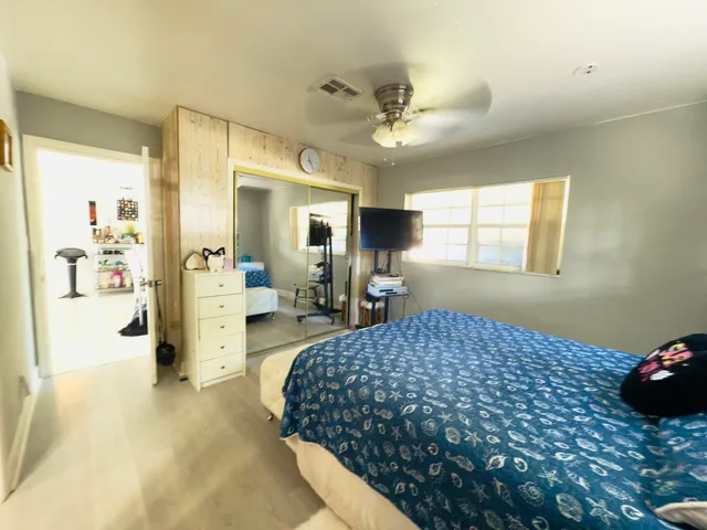 a living room with furniture a flat screen tv and floor to ceiling window