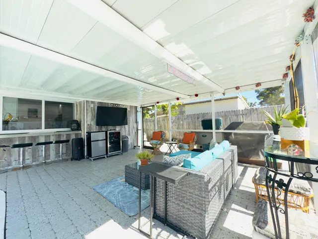 a view of a house with a yard and table and chairs under an umbrella