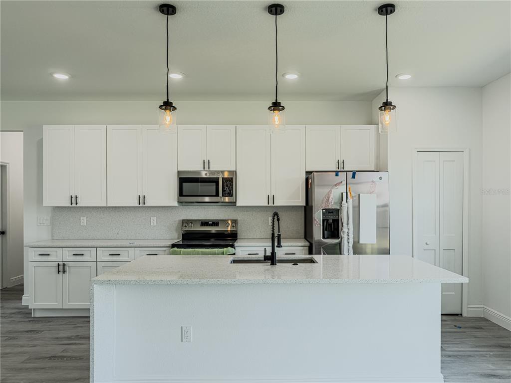 14245 Southwest 28th Court Ocala, FL 34473 - Photo 29 of 85 a view of a kitchen with stainless steel appliances granite countertop a refrigerator a sink a stove and white cabinets