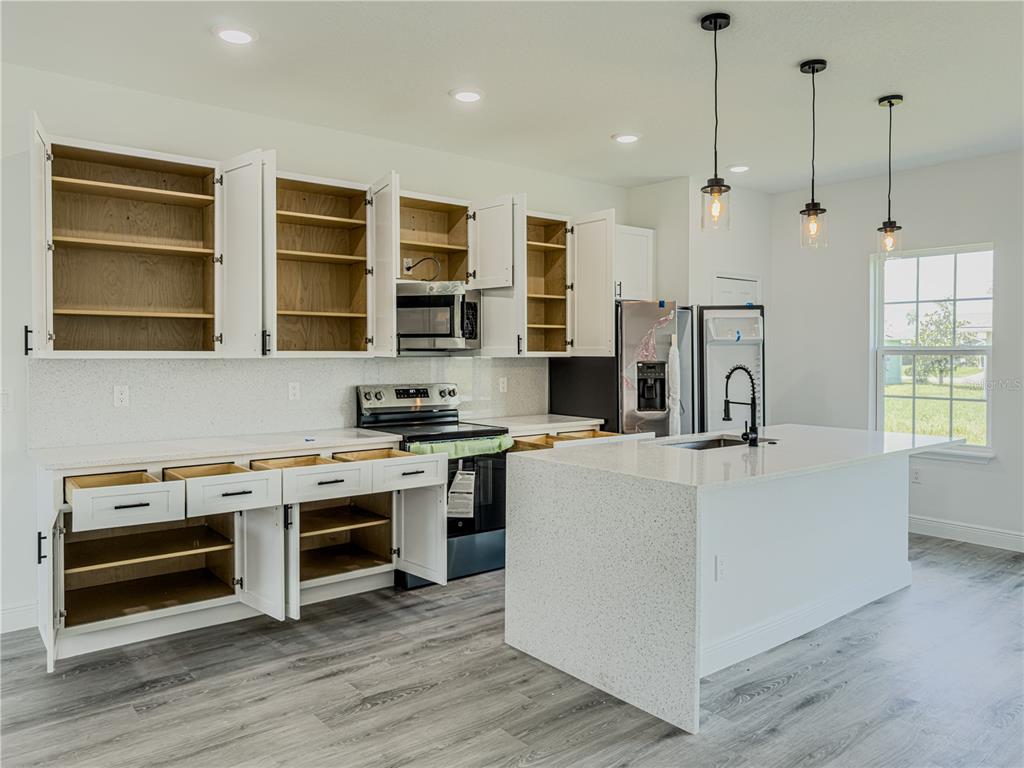 14245 Southwest 28th Court Ocala, FL 34473 - Photo 39 of 85 a kitchen with stainless steel appliances a stove a refrigerator a oven and white cabinets with wooden floors