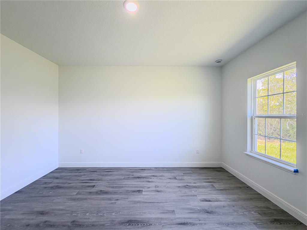 14245 Southwest 28th Court Ocala, FL 34473 - Photo 57 of 85 a view of an empty room with wooden floor and a window
